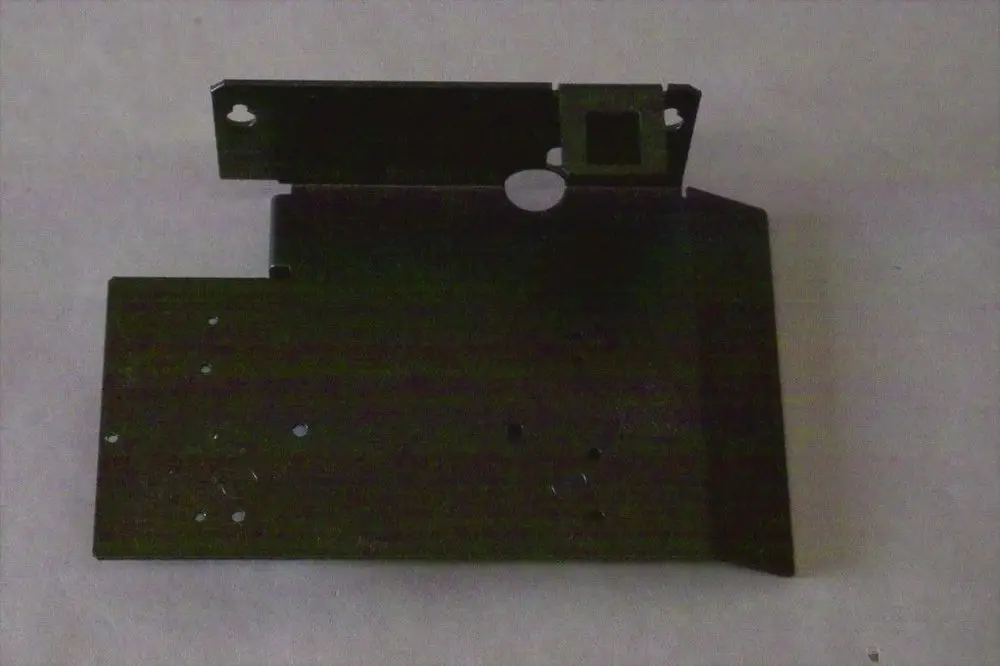 Schwarze Metallhalterung mit verschiedenen Ausschnitten und Löchern, möglicherweise für ein Heizgerät der Marke Brötje.
