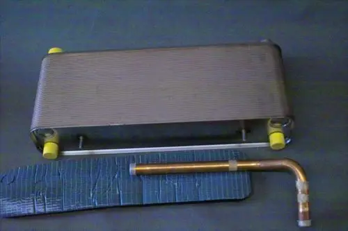 Brötje Verdampfer mit länglicher, gewellter Oberfläche und zwei gelben Dämpfungselementen. Ein Kupferrohr ist an der Seite angebracht.
