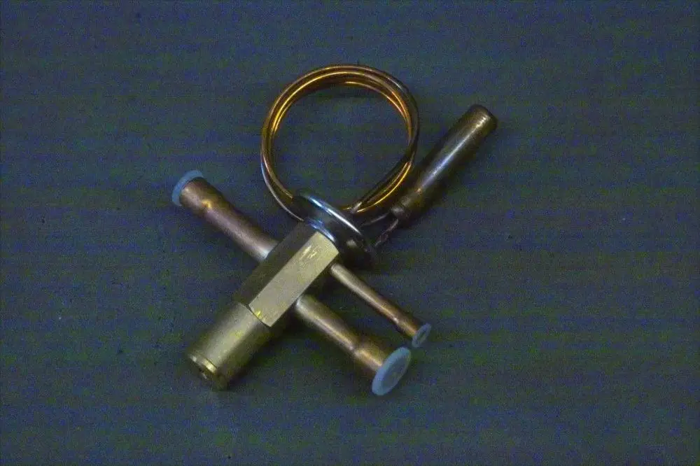Brötje Expansionsventil mit mehreren Rohren und einer Metallringstruktur auf grauem Untergrund.