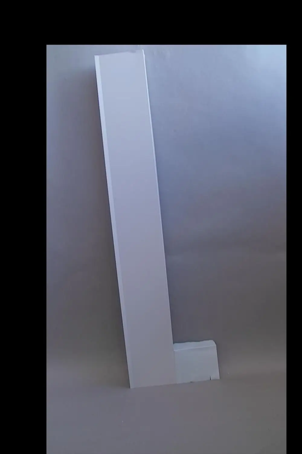 Weißes, vertikales Blech mit einer L-Form, das an der Unterseite eine horizontale Erweiterung aufweist. Produkt von Brötje, geeignet für Schieferdächer.