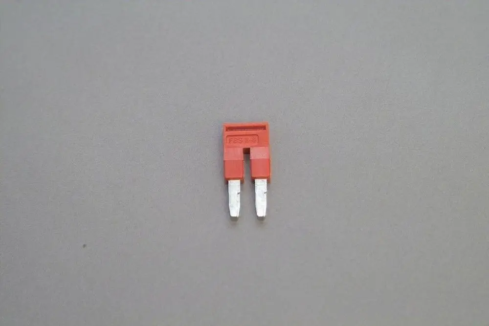 Rote Brücke für elektrische Klemmleiste von Brötje, mit zwei Anschlussklemmen, auf neutralem Hintergrund.