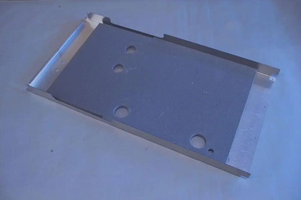 Aluminiumrückwand mit mehreren runden Löchern, geeignet für die Verkleidung von Heizungsanlagen, möglicherweise von der Marke Brötje.