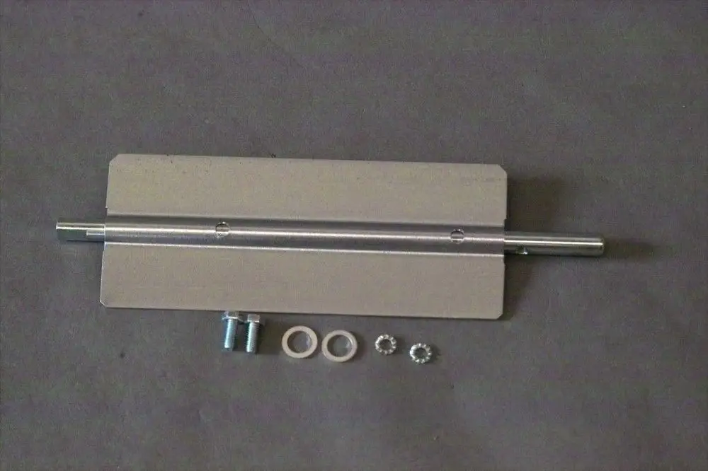 Brötje-Luftklappe mit Metallträger, einem Zylinder und verschiedenen Befestigungsteilen, darunter Schrauben und Dichtungen, auf neutralem Hintergrund.