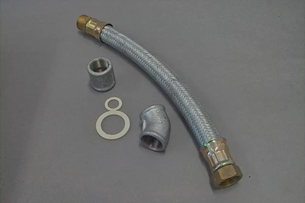 Brötje Schlauch mit Metallanschlüssen und einer gebogenen Form, um Flüssigkeiten zu leiten. Zubehörteile wie Verbindungsmuffe und Dichtungen sind ebenfalls abgebildet.