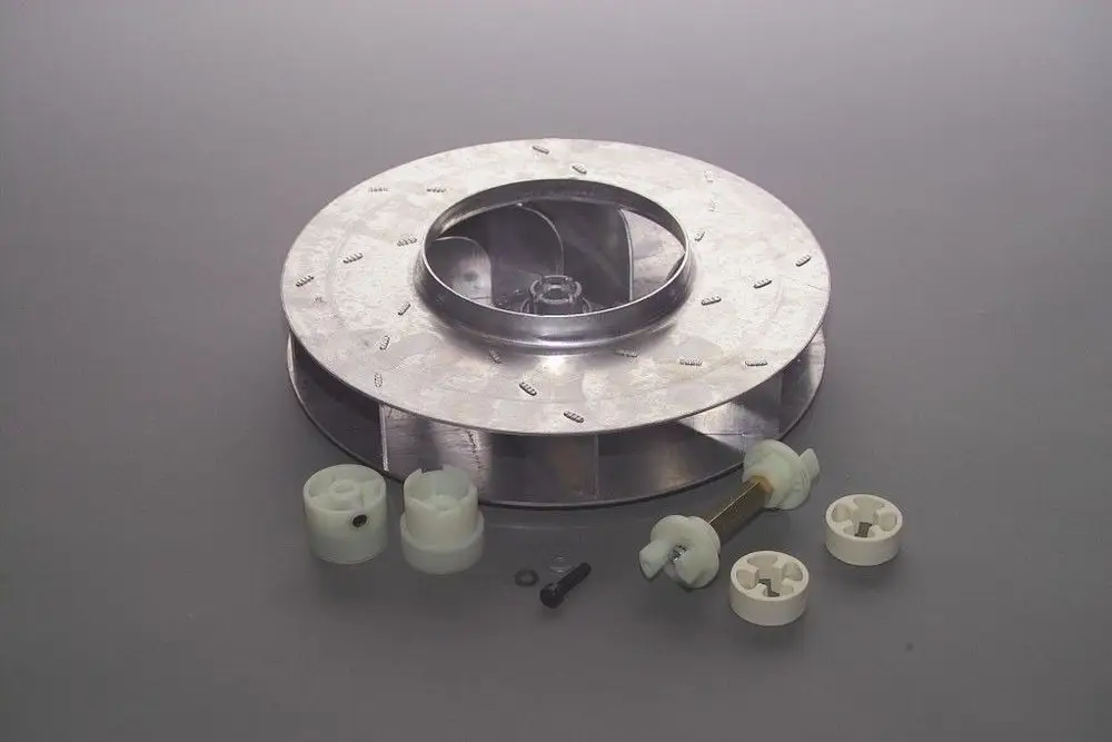 Metallisches Gebläserad mit mehreren weißen Kunststoffteilen und einem Metallstift, geeignet für Brötje-Geräte, auf grauem Hintergrund.