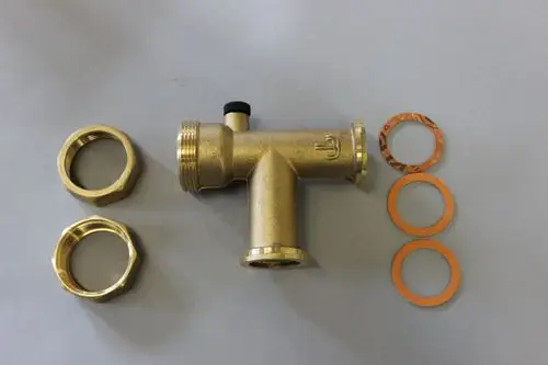 Brötje Schwerkraftsperre in Goldfarbe, mit zwei Sechskannungsmuttern und drei Dichtungsringen, auf grauem Untergrund.