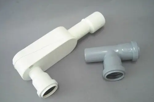Zwei PVC-Rohre, eines in Weiß und eines in Grau, mit einem T-Stück und einem geraden Abschnitt. Teile sind für Installationen von Brötje geeignet.