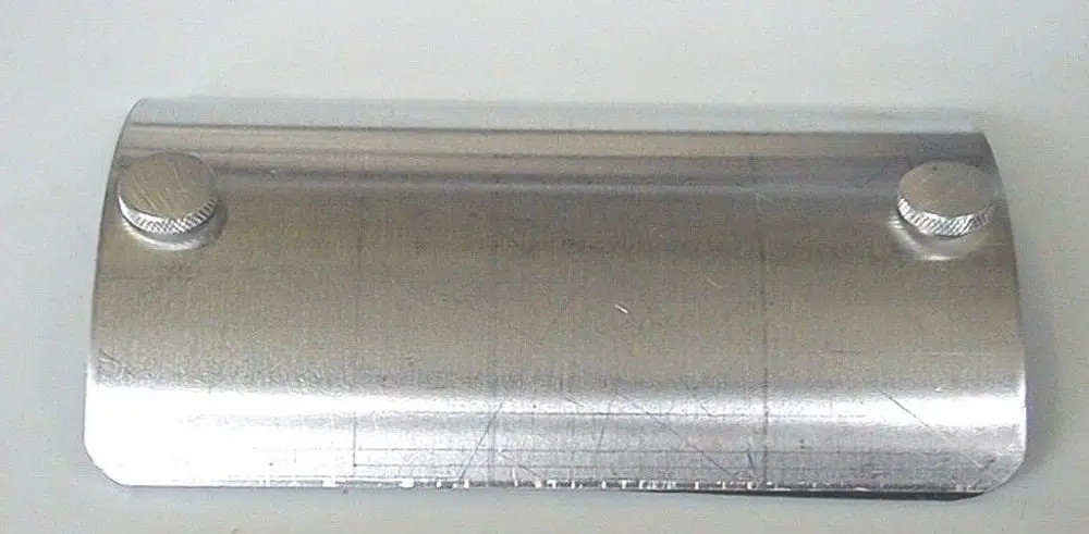 Reinigungstür von Brötje aus Metall mit zwei Rändelschrauben, gebogen, glänzende Oberfläche und gerade Kanten.