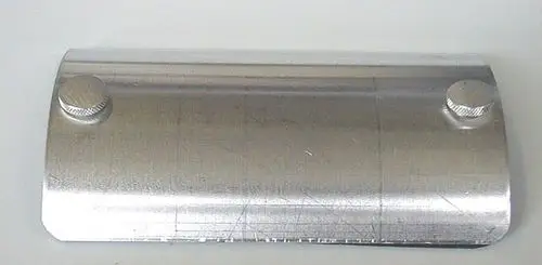 Reinigungstür von Brötje aus Metall mit zwei Rändelschrauben, gebogen, glänzende Oberfläche und gerade Kanten.