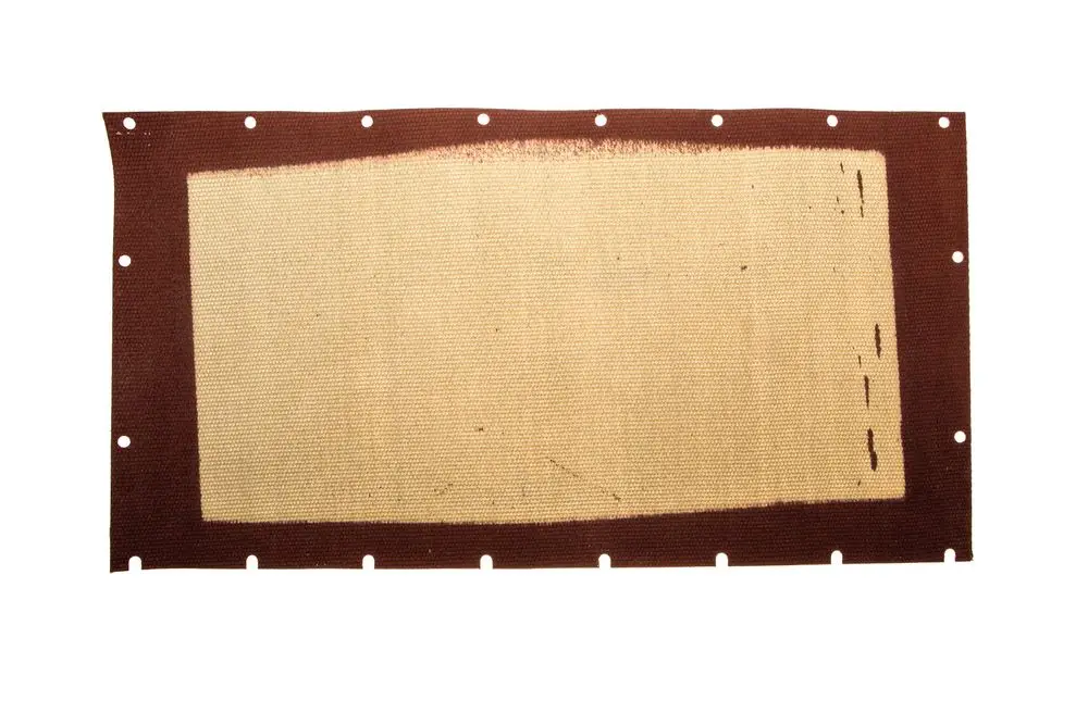 Brötje Dichtung für Wartungsklappe, rechteckige Form mit braunem Rand und beige Innenfläche, mehrere Löcher zur Befestigung auf einer strukturierten Oberfläche.