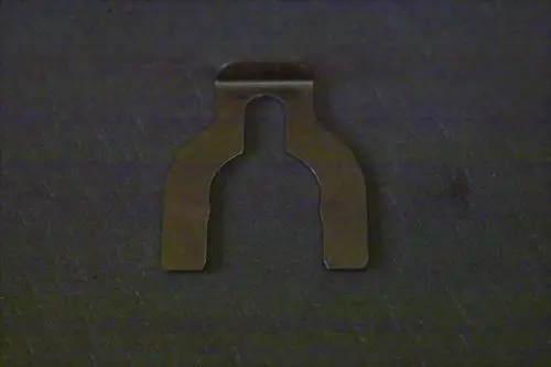 Metallclip in Form eines 3-Wege-Ventils, passend für Brötje Produkte, auf dunklem Hintergrund liegend.