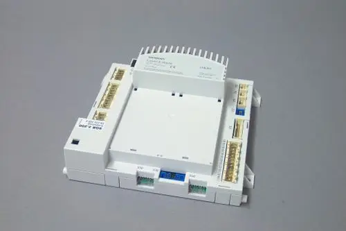 Weißes elektrisches Steuergerät mit Anschlussklemmen auf mehreren Seiten. Markierung und Typenbezeichnungen sind sichtbar. Dient zur Regelung von Heizsystemen von Brötje.