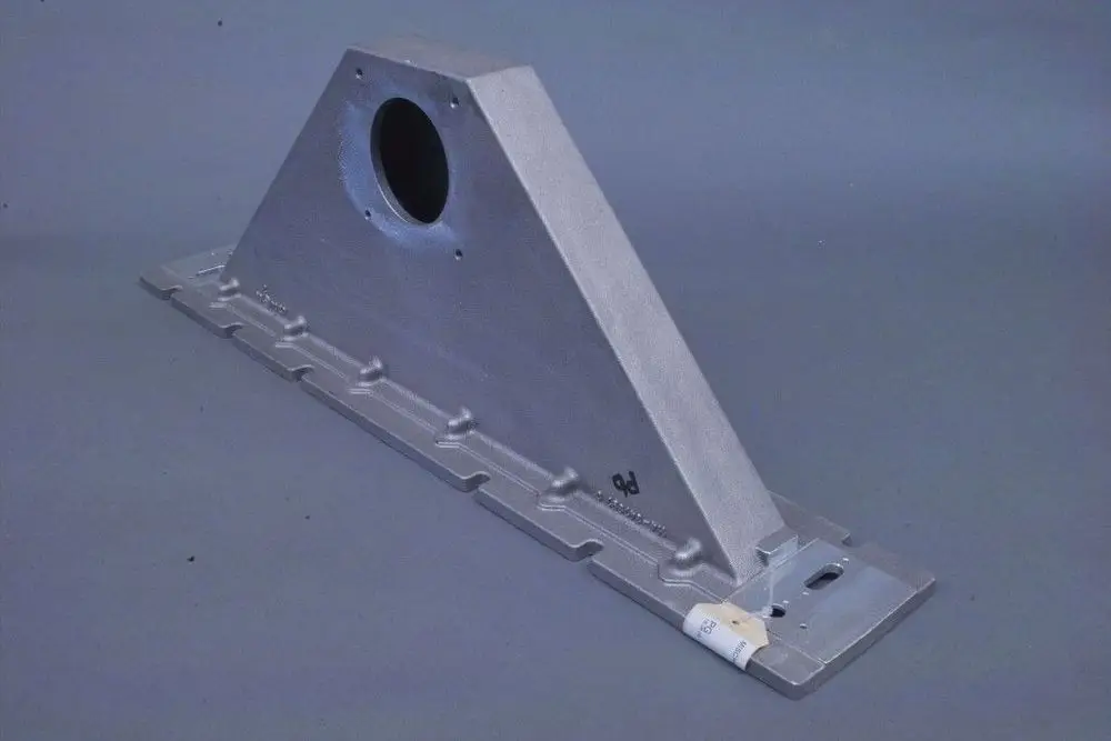 Aluminium-Mischkanal von Brötje, in dreieckiger Form mit einer zentralen Öffnung, auf grauem Hintergrund präsentiert.