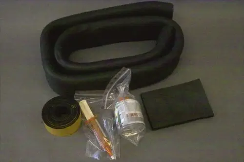 Reparaturset von Brötje mit mehreren Komponenten, darunter ein flexibler Schlauch, eine Tube mit Dichtmittel, ein Stück Schaumstoff und ein Band in Schwarz und Gelb, verpackt in Plastiktüten.