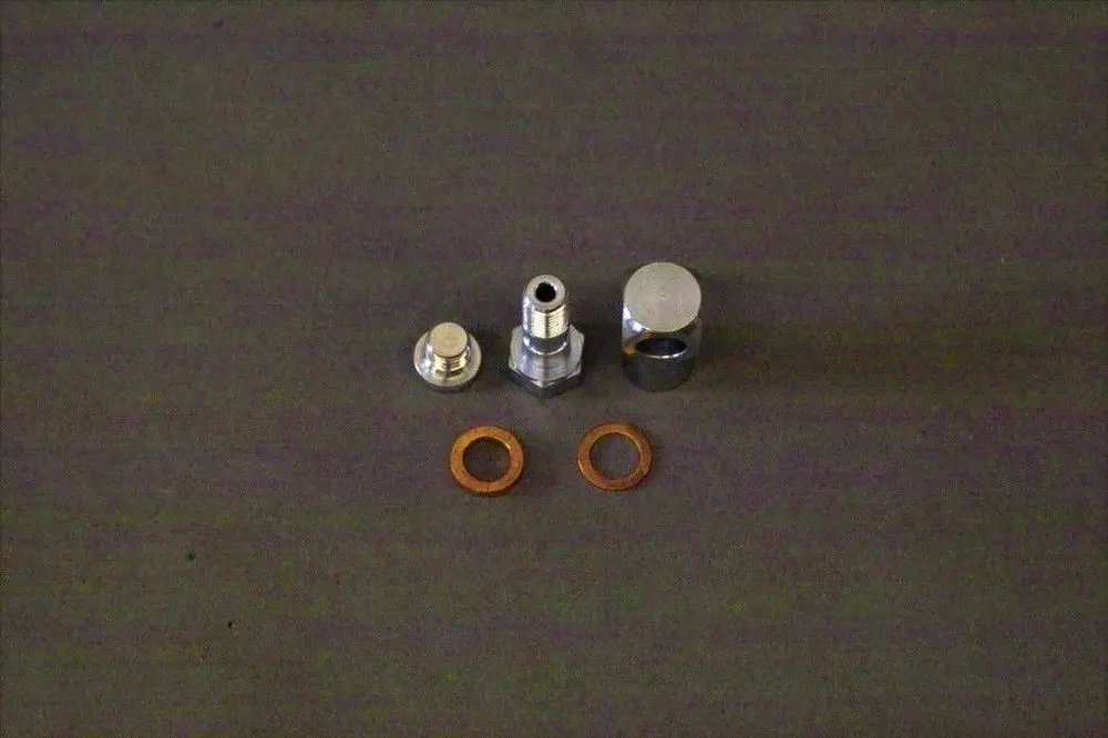Brötje Nippel OZA 1/2, bestehend aus mehreren metallischen Teilen und Dichtungen, auf einer neutralen Unterlage angeordnet.