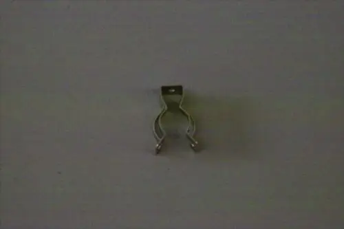 Brötje Arretierclip in metallischer Ausführung, mit zwei gebogenen Haltefüßen und einer oberen Verankerung, abgestellt auf einer neutralen Oberfläche.