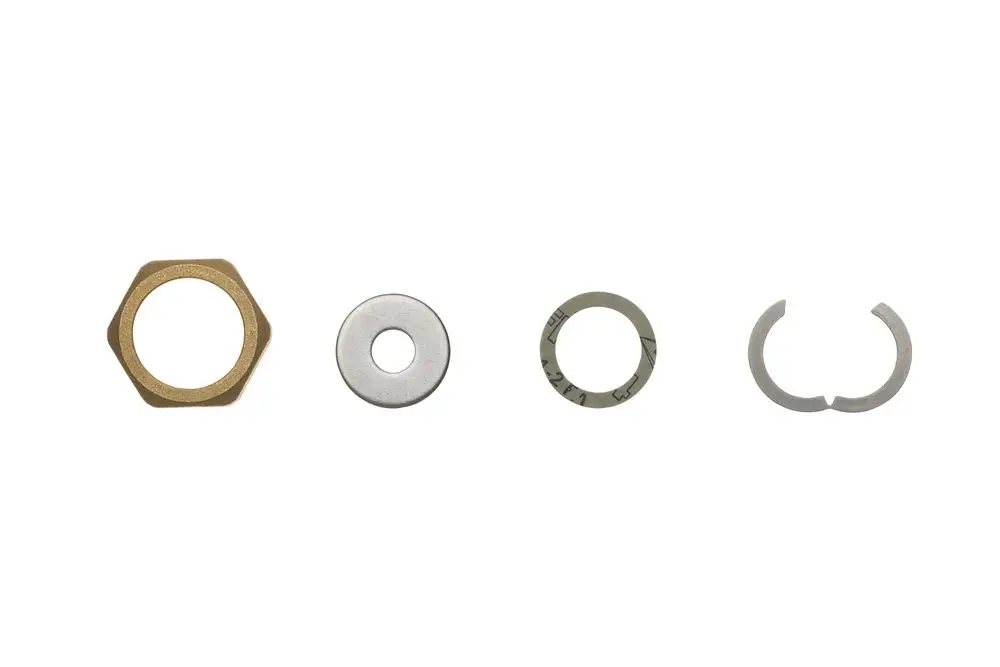 Fünf verschiedene Verbindungselemente aus Metall, darunter eine Mutter, eine Unterlegscheibe, eine Beilagscheibe und ein Sicherungsring, präsentiert auf weißem Hintergrund. Brötje Fitting Set.