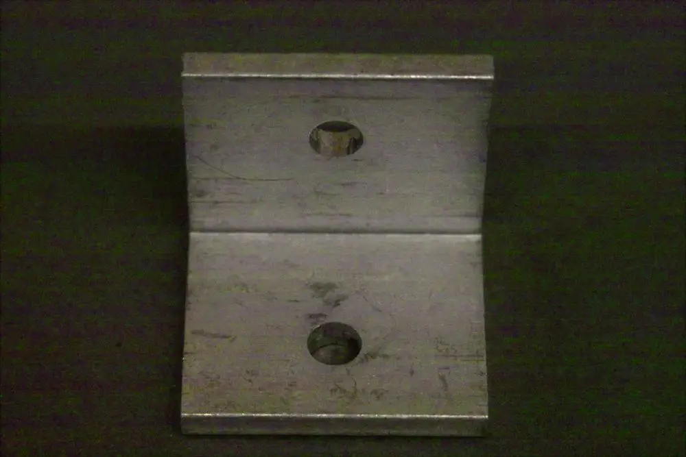 Metallischer Winkel mit zwei Bohrungen, klar erkennbar in der Brötje Produktgestaltung. Geeignet für verschiedene Befestigungsanwendungen.