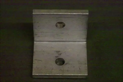 Metallischer Winkel mit zwei Bohrungen, klar erkennbar in der Brötje Produktgestaltung. Geeignet für verschiedene Befestigungsanwendungen.