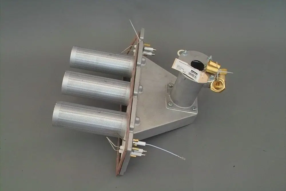 Brötje Brenner mit drei Zylindern, einem Anschluss für die Gaszufuhr und verschiedenen Leitungen. Das Produkt ist aus Metall gefertigt und hat eine einfache, funktionale Bauweise.