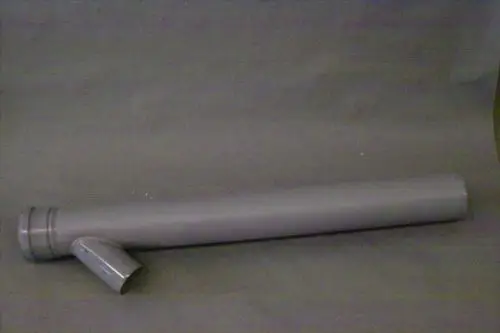 Graues Rohr mit seitlichem Abzweig, möglicherweise von Brötje. Das Rohr hat eine gerade Form und einen Anschluss an einer Seite. Hintergrund in neutralem Ton.
