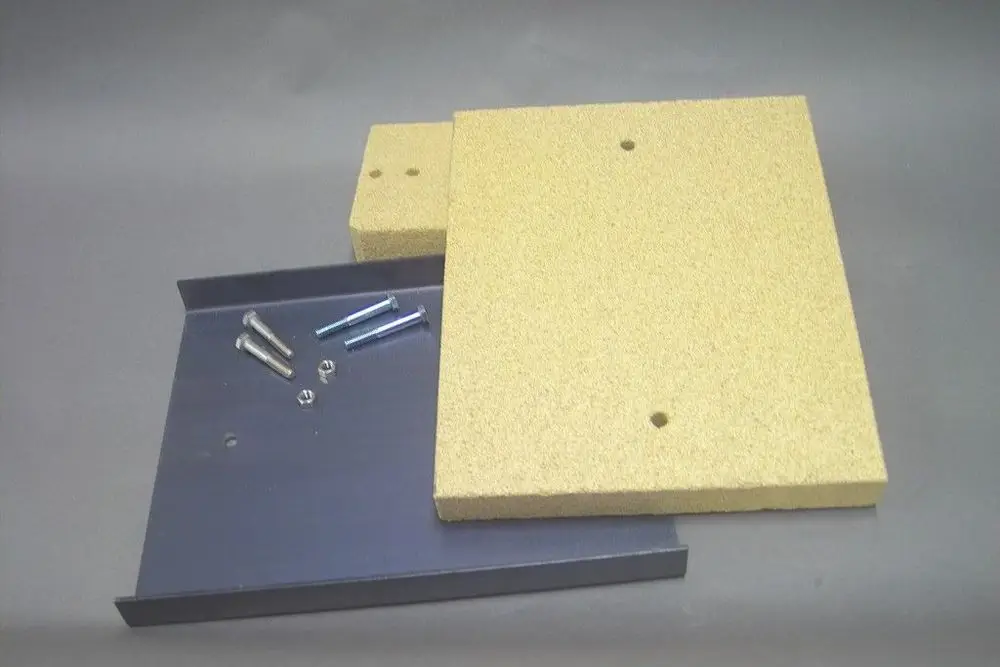 Isolationsplatten und Schrauben von Brötje, angeordnet auf einer grauen Unterlage. Die Platten sind aus einem hellen Material, die Schrauben sind aus Metall.