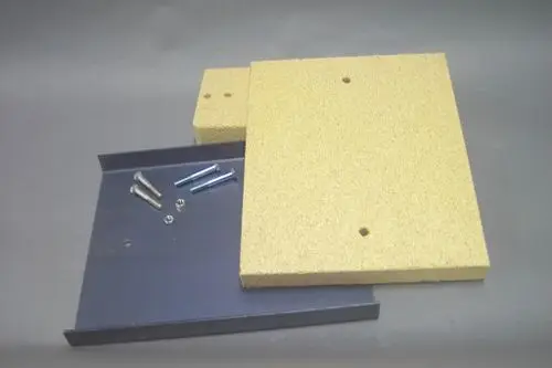Isolationsplatten und Schrauben von Brötje, angeordnet auf einer grauen Unterlage. Die Platten sind aus einem hellen Material, die Schrauben sind aus Metall.