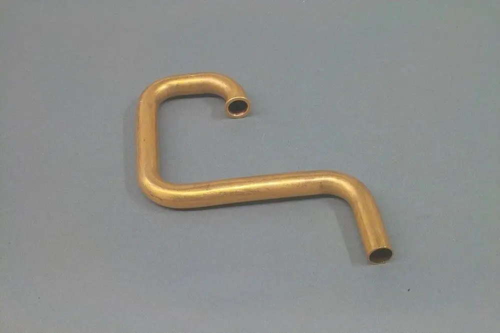 Kupferrohr in Form eines L mit zwei offenen Enden. Es könnte Teil eines Heizungs- oder Wasserversorgungssystems von Brötje sein.