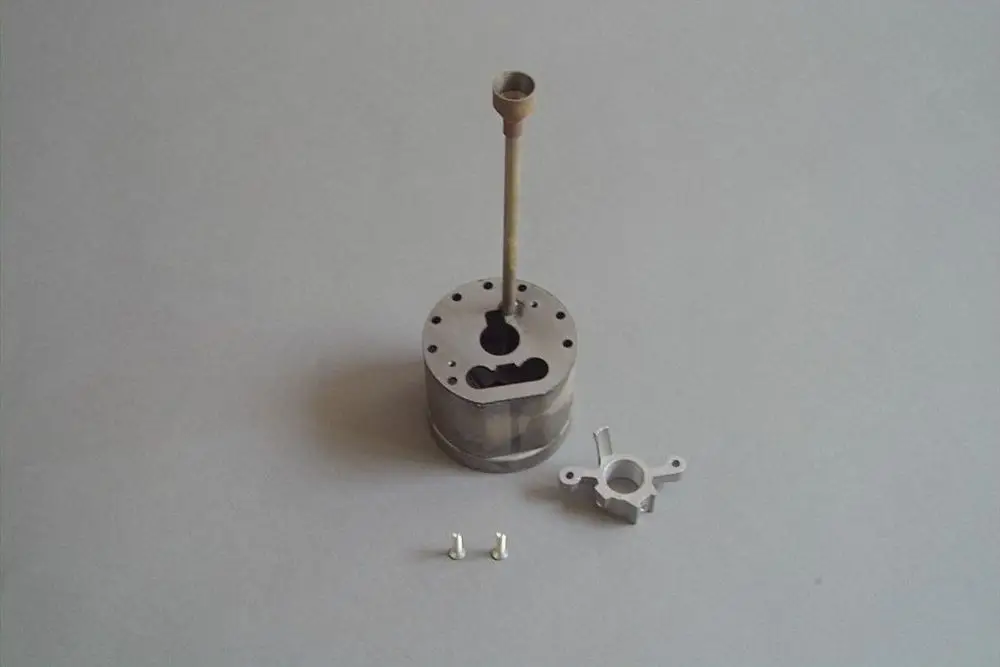 Brötje Stauscheibe aus Metall mit einem länglichen Stab und zwei kleinen, separaten Metallteilen auf einem grauen Hintergrund.