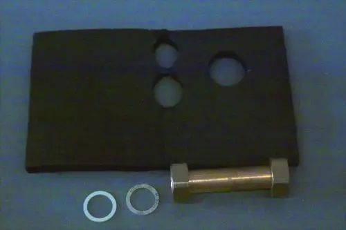 Brötje Rücklaufrohr mit zwei kreisförmigen Öffnungen in einer rechteckigen Platte, ergänzt durch eine metallene Verbindungsstück und zwei runde Dichtungen.