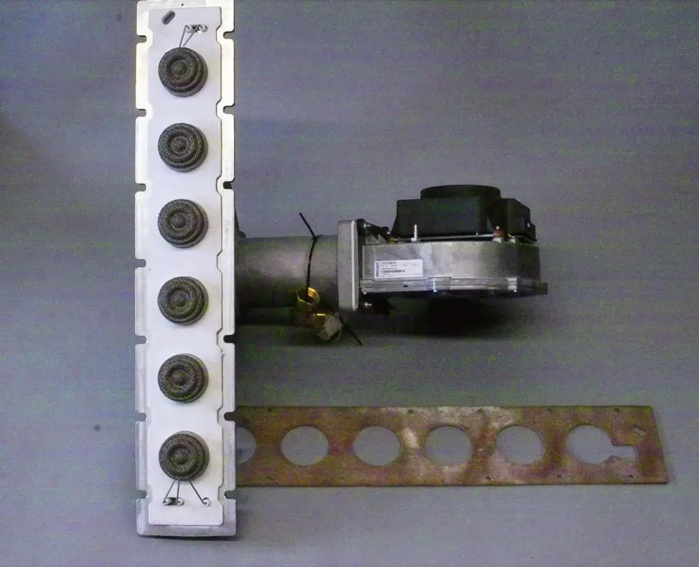 Brötje Brenner mit Metallgewebe, bestehend aus mehreren spiralförmigen Metallkomponenten und einem angeschlossenen Gehäuse, das eine technische Apparatur darstellt.