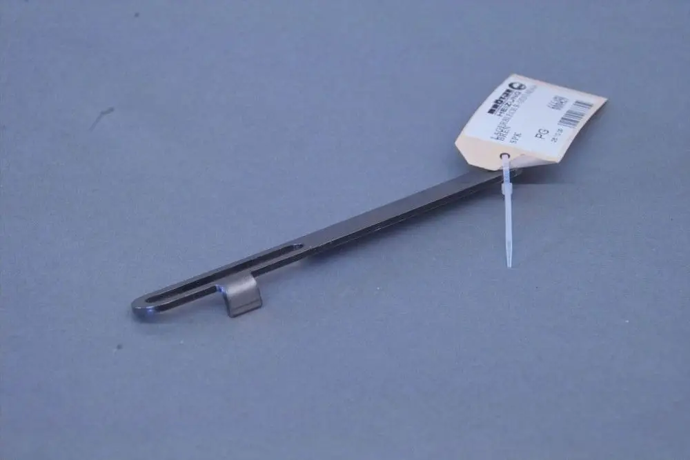 Brötje Lagerblech, flaches Metallteil mit einer länglichen Form und einem seitlichen Haken, auf grauem Hintergrund, mit Preisschild und Befestigungsring.