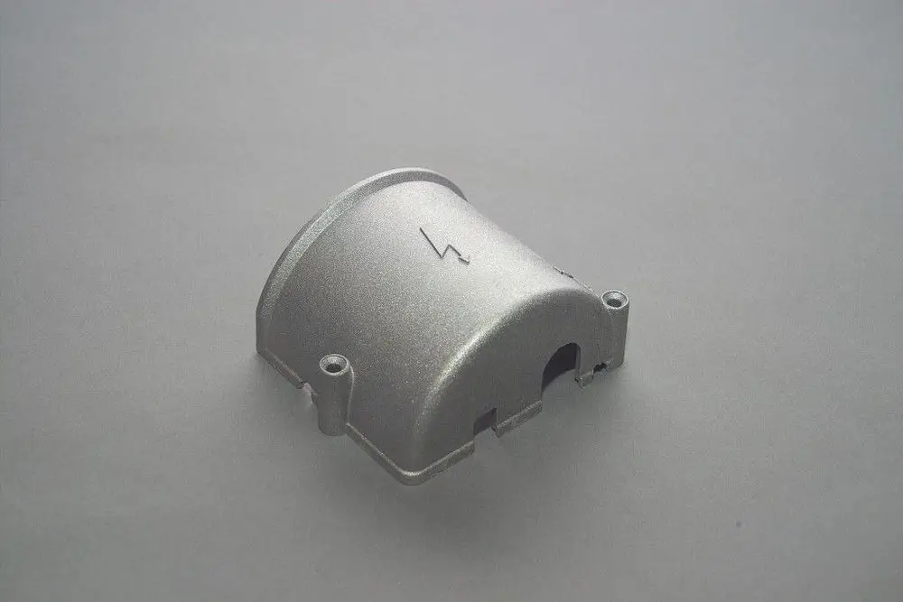 Aluminium-Gehäusedeckel von Brötje, mit einer Aussparung und einem symbolischen Blitz auf der Oberfläche, vor einem grauen Hintergrund platziert.