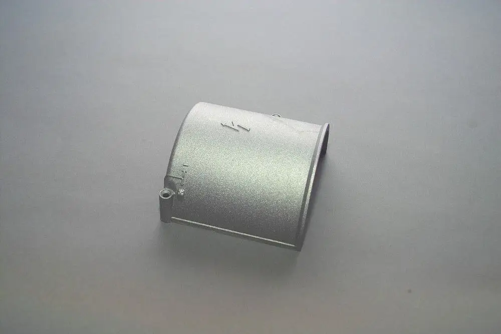 Brötje Deckel in silberner Farbe, rund mit einer seitlichen Öffnung. Die Oberfläche ist glatt und glänzend, auf einem einfarbig grauen Hintergrund platziert.