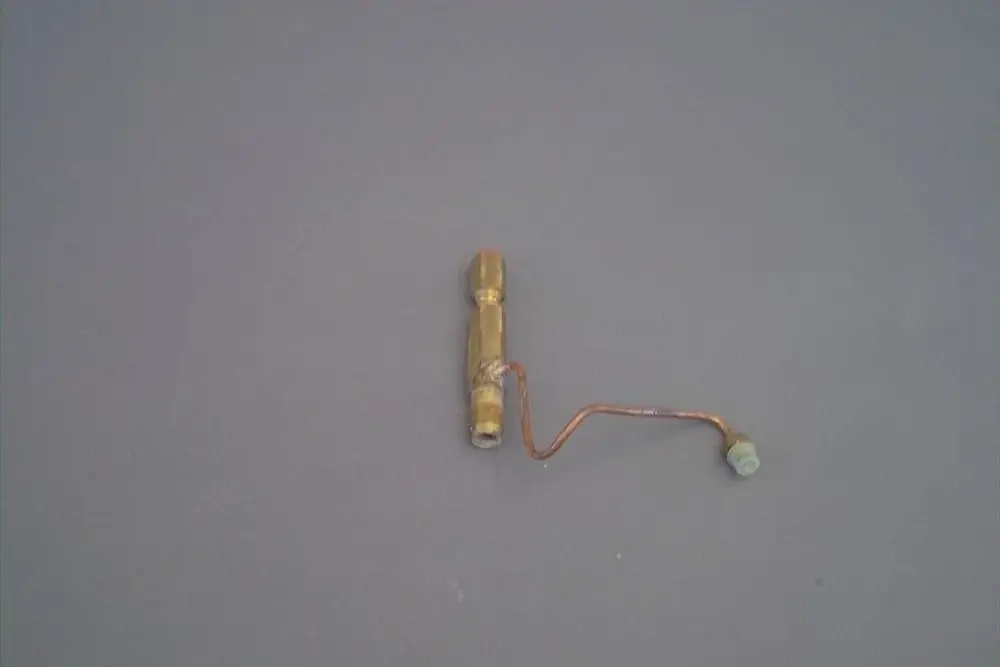 Brötje Düsenstock in metallischer Ausführung, mit einem verästelten Rohr und verschiedenen Anschlussstellen, auf grauem Hintergrund platziert.