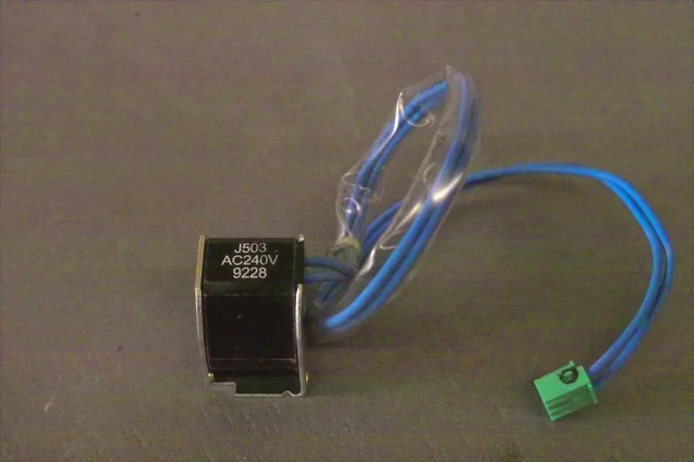 Brötje Magnetventilspule mit zwei blauen Anschlusskabeln und grünem Stecker. Der Körper ist schwarz mit der Aufschrift „J503 AC240V 9228“.