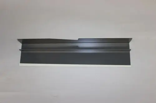 Brötje Verbindungselement in schwarzem Finish, flache Bauweise mit zwei parallelen Leisten und einer seitlichen Aussparung, auf grauem Hintergrund platziert.