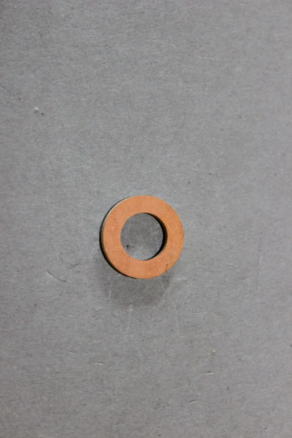 Brötje Dichtung in Ringform auf grauem Hintergrund, mit einer zentralen Öffnung und einem flachen, gleichmäßigen Profil.