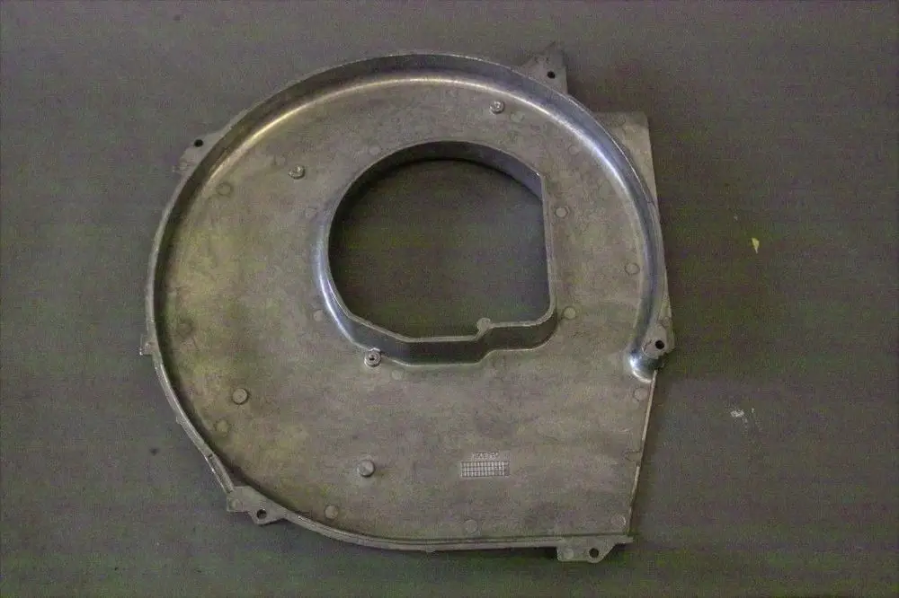 Brötje Haube aus Metall mit runder Öffnung und mehreren Befestigungslöchern, platziert auf einer dunklen Oberfläche.