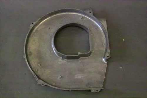 Brötje Haube aus Metall mit runder Öffnung und mehreren Befestigungslöchern, platziert auf einer dunklen Oberfläche.