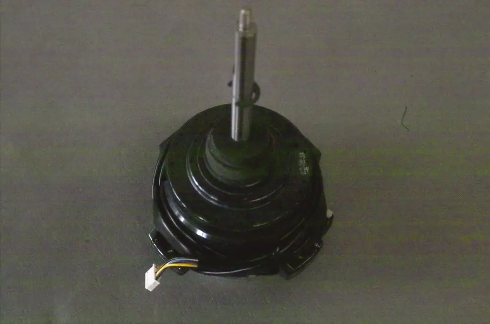 Schwarzer Gebläsemotor von Brötje mit zentralem Wellenstift und einem Kabelanschluss, betrachtet von oben auf grauem Untergrund.