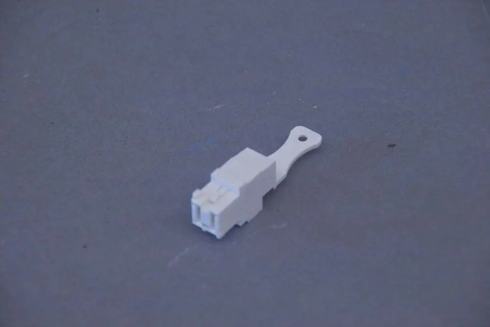 Weißes Kunststoffteil mit einer Kontaktbuchse und einem Befestigungsring, typisch für Brötje Produkte im Bereich der Elektroinstallation.