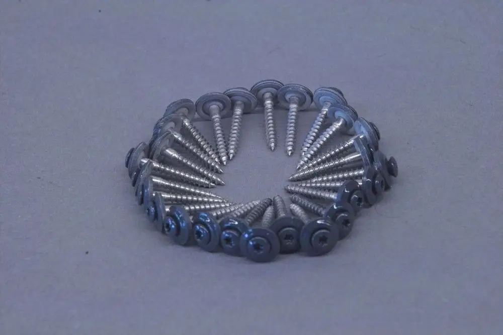 Kreisförmig angeordnete Spenglerschrauben aus Metall mit einem flachen Kopf und Schraubengewinde, charakteristisch für Produkte der Marke Brötje.
