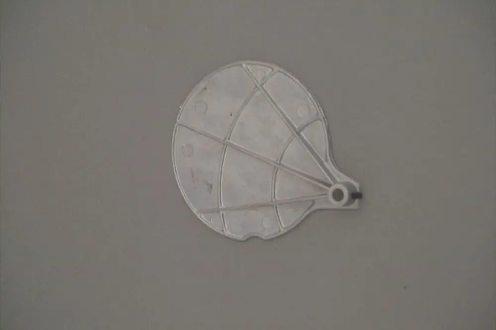 Brötje Luftklappe in Form eines kreisförmigen Elements mit mehreren Aussparungen und Linien, auf grauem Untergrund.