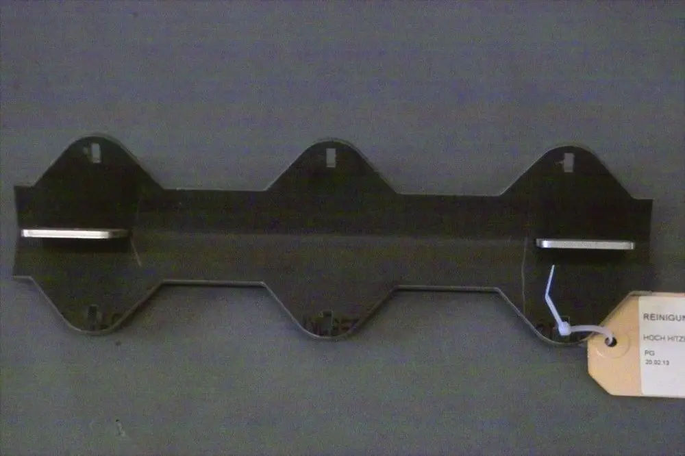 Schwarze Reinigungswippe mit zwei horizontalen Metallstreifen, angebracht an einer Wand. Namensschild mit der Marke Brötje und weiteren Informationen ist an der Wippe befestigt.