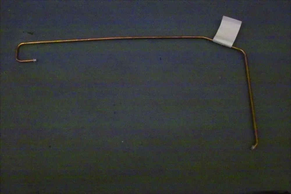 Kupferne Leitung mit gebogener Form und einem kleinen weißen Etikett, möglicherweise für den Außendruckabgleich eines Brötje Heizsystems.