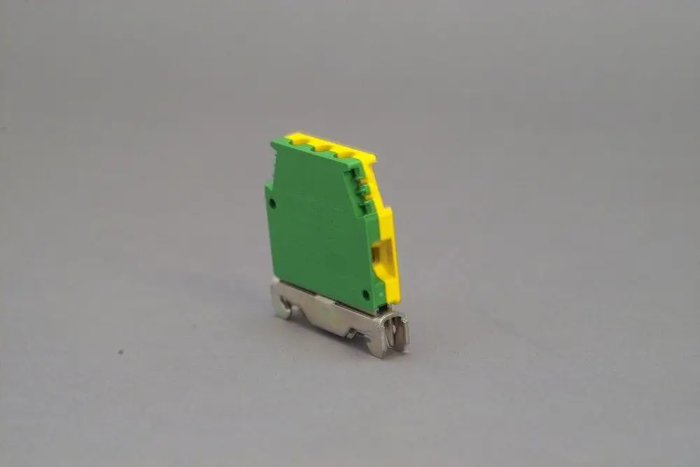 Brötje Erdungsklemme in Grün-Gelb mit einer Metallbasis, für die sichere Verbindung von Leitungen, auf neutralem Hintergrund dargestellt.