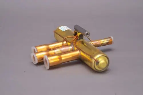 Brötje Vierwegeventil mit mehreren Rohren, das in einem zusammengebauten Zustand gezeigt wird. Die Bestandteile sind in einer metallischen Farbgebung und auf einem grauen Hintergrund dargestellt.