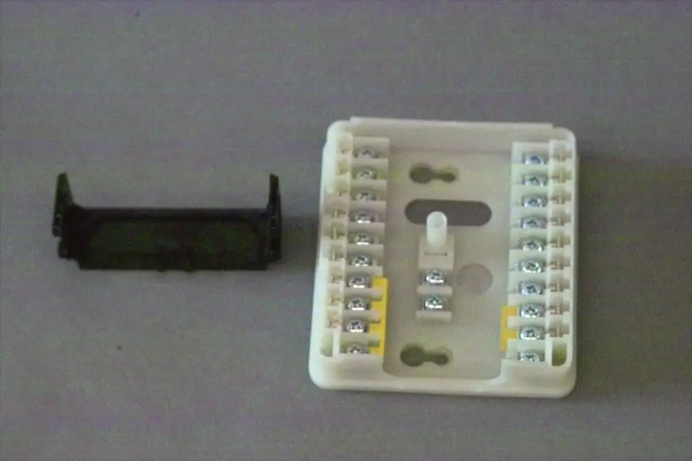 Brötje Anschlussplatte mit mehreren Schraubklemmen, kombiniert mit einer Abdeckung. Das Produkt dient zur elektrischen Verbindung in Heizsystemen.