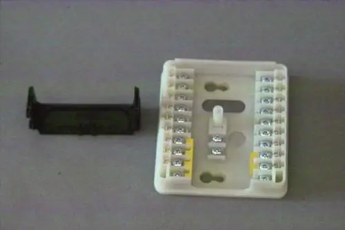 Brötje Anschlussplatte mit mehreren Schraubklemmen, kombiniert mit einer Abdeckung. Das Produkt dient zur elektrischen Verbindung in Heizsystemen.